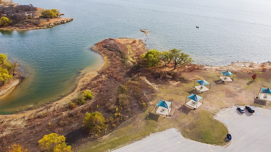 Scenic shoreline with buffs, cliffs view on the northern shores of Lake Grapevine. Aerial view tent only campsites with convenience parking, pads, fire rings, and grills at Murrell Park, Texas