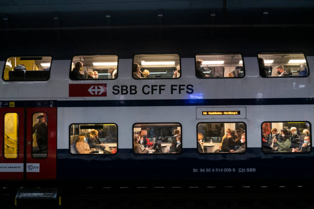 Passengers wearing face mask on a train in Zurich, Switzerland Zurich, Switzerland - November 3, 2021: Passengers wearing face masks due to the coronavirus pandemic sit on a Swiss train about to depart Zürich Hauptbahnhof. zurich train station stock pictures, royalty-free photos & images