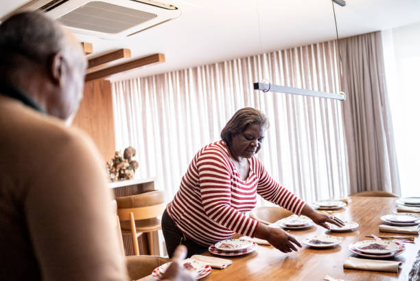 istock Senior couple setting the table for dinner or lunch at home 1356952750