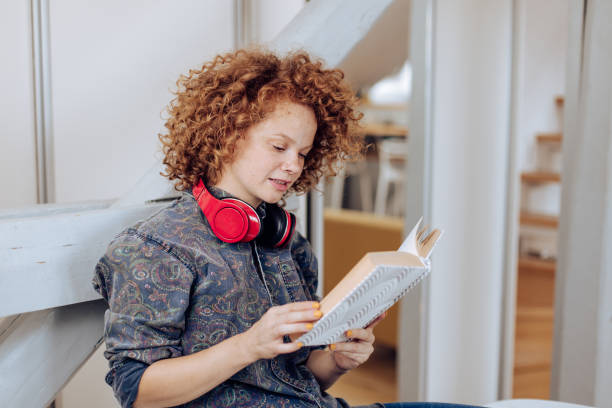 istock Beautiful girl reading at her home office 1356952830