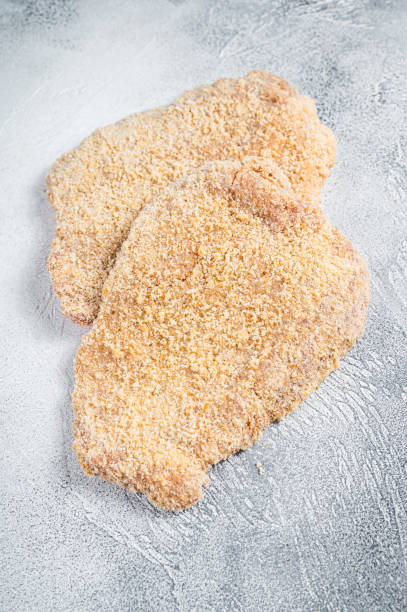 raw chicken schnitzel escalope in breadcrumbs. white background. top view - viennese schnitzel imagens e fotografias de stock