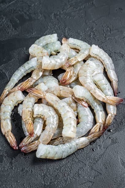 istock Fresh raw black shrimps prawns on a stone Board. Black background. Top view 1356955068