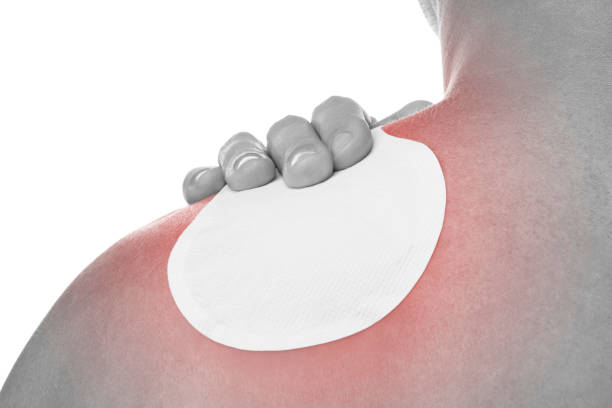 istock Young man applaying a heat patch for shoulder pain. 1356957647