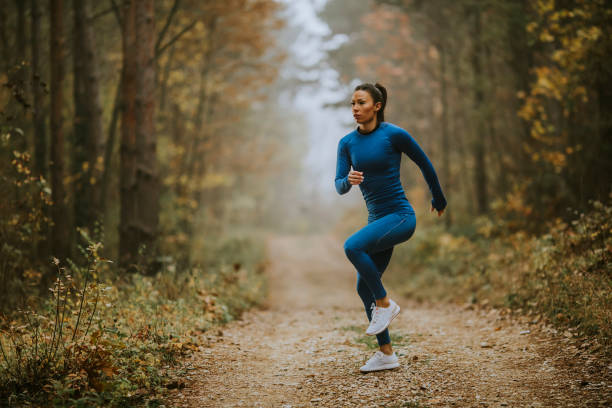 istock Young woman running having exercise on forest trail at autumn 1356959315