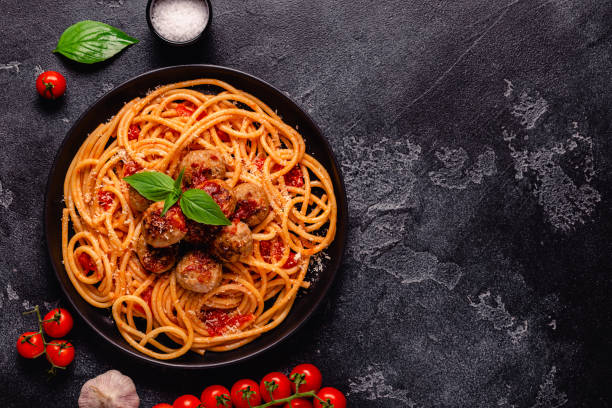 Spaghetti with meatballs and tomato sauce on a stone background stock photo