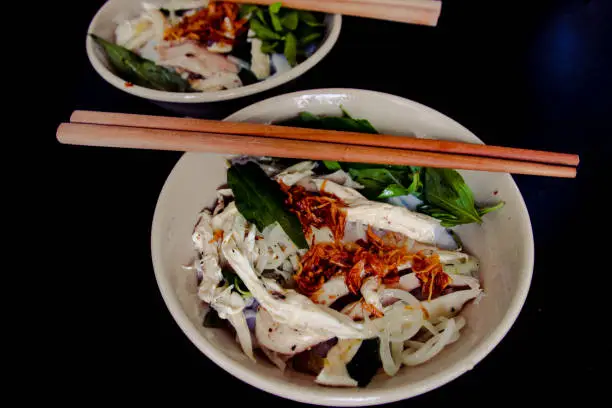 Banh Uot Long Ga, unique vietnamese dry rice noodles (flat and wide like wet rice cake noodle) dish mixed with herbs and meat, a local delicacy of Da lat Vietnam