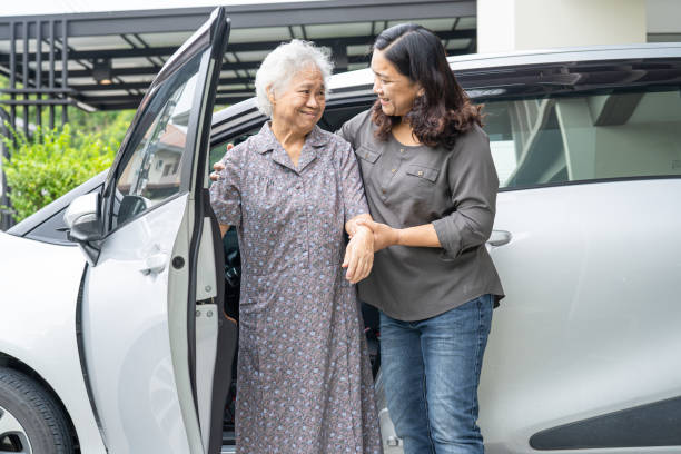 hilfe und unterstützung asiatischer senior oder älterer alter patientin, die im rollstuhl sitzt, bereiten sie sich darauf vor, zu ihrem auto zu gelangen, gesundes starkes medizinisches konzept. - paralyze stock-fotos und bilder