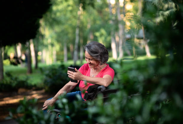 istock Senior woman using mobile phone in park. 1356962826