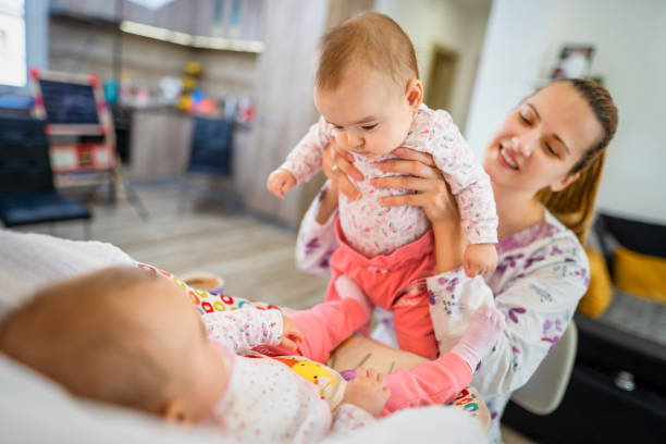istock Young mother playing with her newborn babies 1356963026