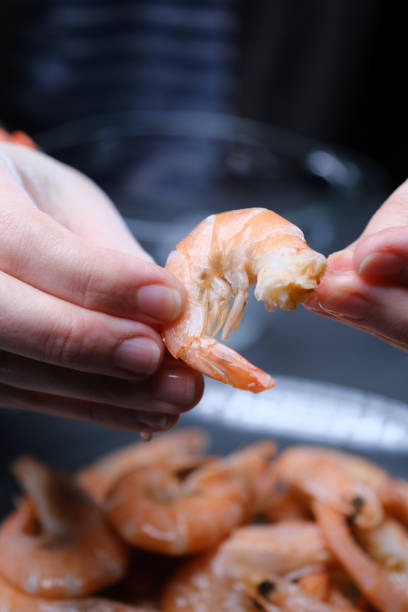 istock Human hands are peeling boiled shrimps 1356964208