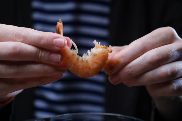 istock Human hands are peeling boiled shrimps 1356964214