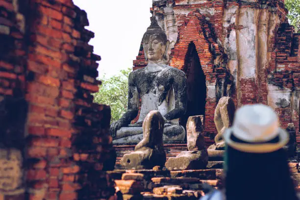 A tourist sightseeing in Wat Choeng Tha, part of the famous Ayutthaya Historical Park in Thailand