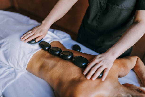 kobieta relaksująca się w beauty spa - massage therapist lastone therapy massaging spa treatment zdjęcia i obrazy z banku zdjęć