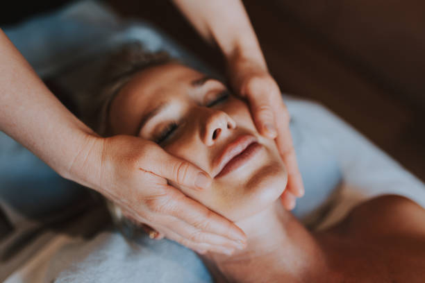 美容スパでリラックスした女性 - facial massage ストックフォトと画像