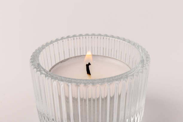 istock Burning tea candles in a glass holder, isolated on white. Space for text 1356972224