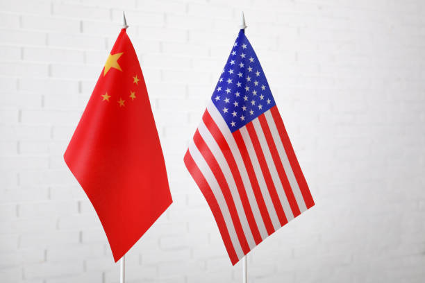 istock USA and China flags against white brick wall. International relations 1356973591
