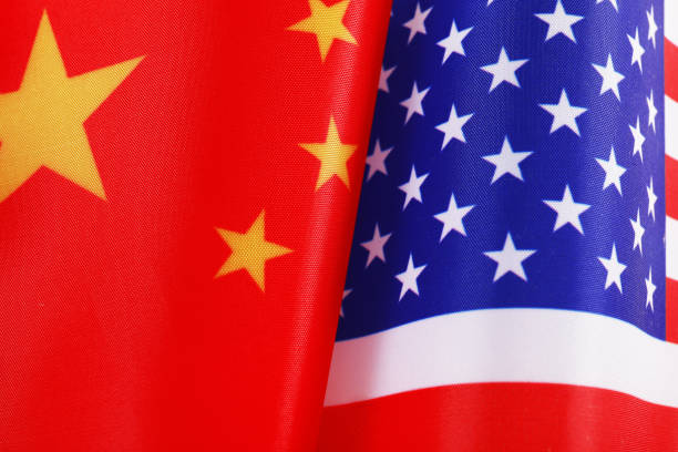 istock USA and China flags as background, top view. International relations 1356974489