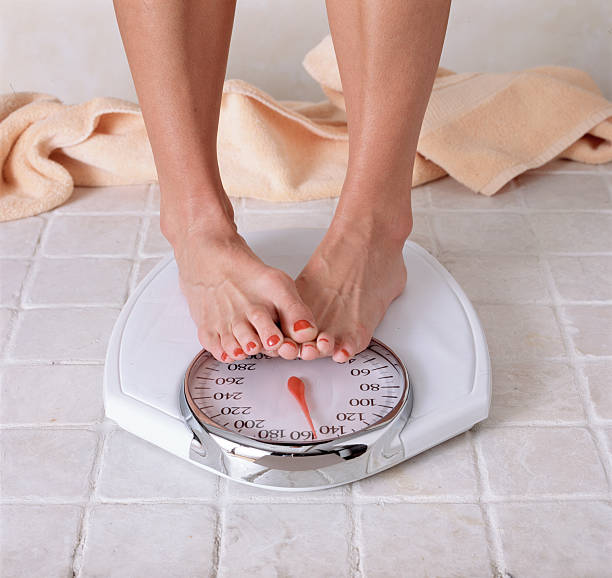 Woman dieting Photo of woman's feet on scale. kilogram stock pictures, royalty-free photos & images