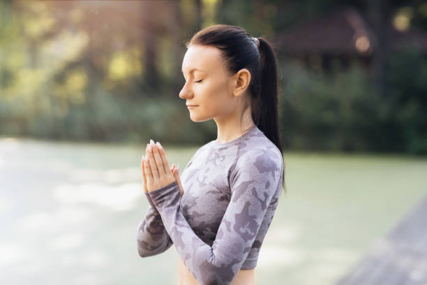 istock Woman practicing yoga, performs meditation with namaste in the park 1356977212