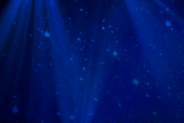 istock Blue blurred stage background with stars and snowflakes. 1356977452