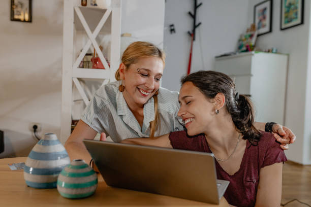 istock Lesbian couple relaxing at home and using mobile phone 1356977606