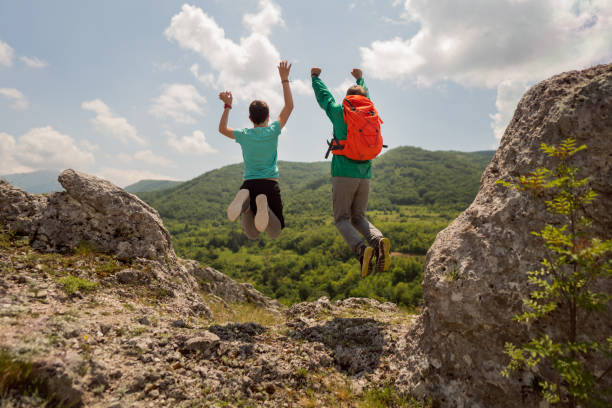 istock Happy father and son, jumping and celebrating their successful hike 1356977774