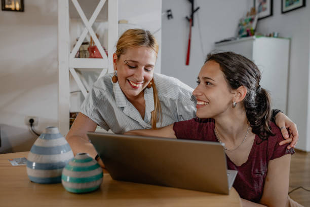 istock Lesbian couple relaxing at home and using mobile phone 1356977862