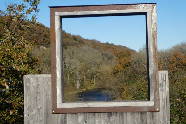 view of the river below through a wooden frame placed near the bridge.the frame is open so depending on our position the view is different. photo taken at Val de Maizet in Calvados, Normandy region