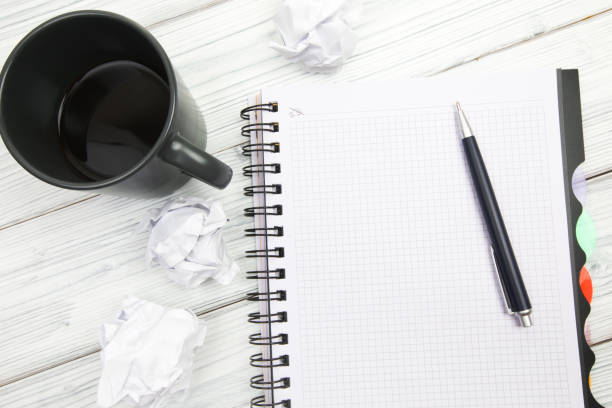 Empty notebook  pen balls and crumpled paper balls on wooden background