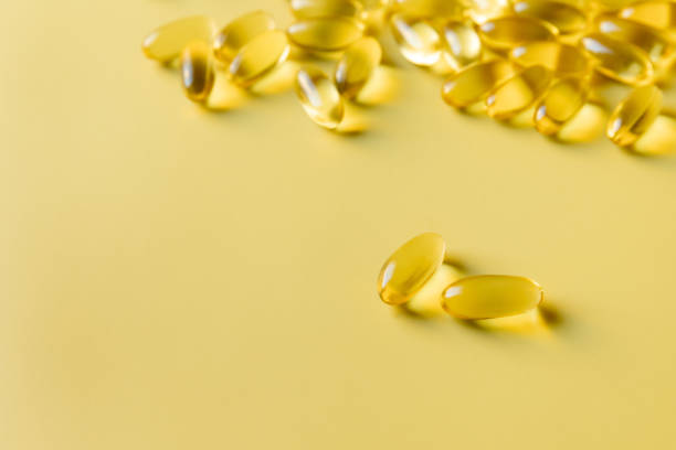 黄色の背景に毎日のサプリメントオメガ-3カプセル - nutritional supplement fish oil vitamin pill bottle ストックフォトと画像