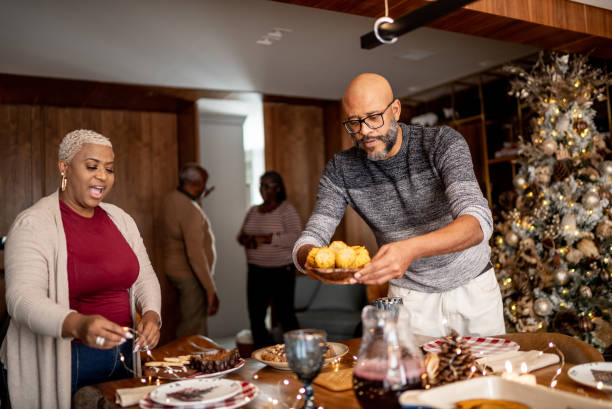 istock Mature couple setting the table for Christmas lunch or dinner at home 1356983592