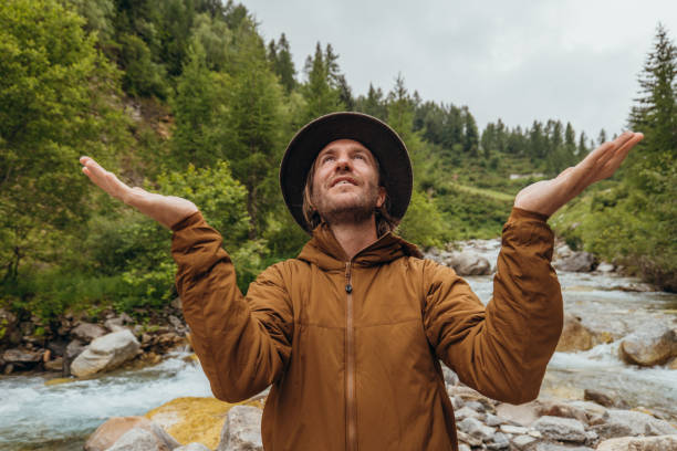 istock Young man by the river contemplating nature 1356983721