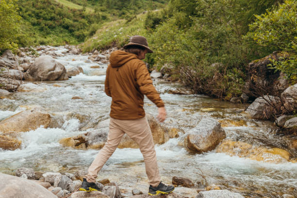 istock Young man by the river contemplating nature 1356983802