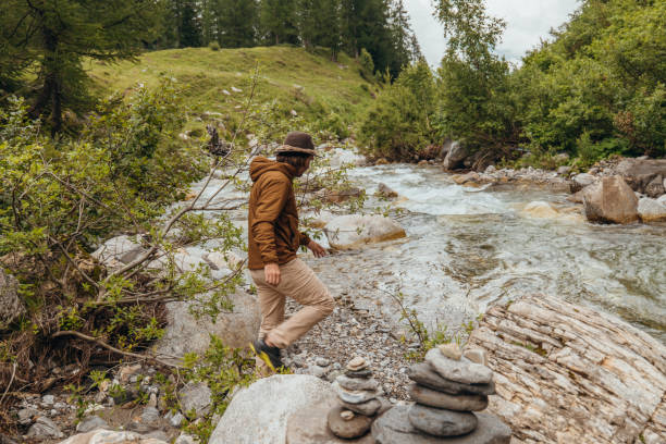istock Young man by the river contemplating nature 1356984810