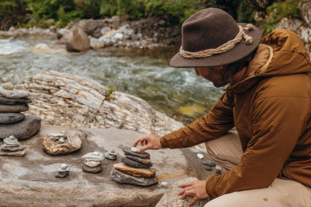 istock Young man staking rocks by the river 1356986054