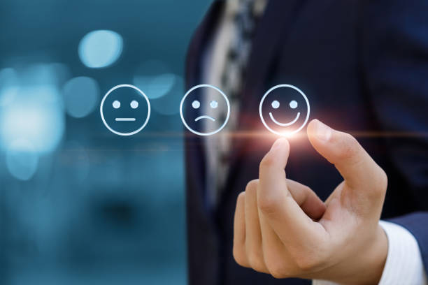 istock Businessman chooses smiling emoticon on blurred background. 1356987530