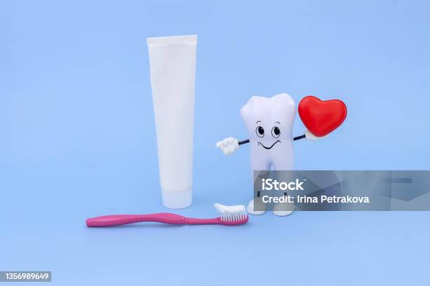 Cartoon Model Of A Tooth Toothpaste Toothbrush And A Heart On A Blue Background Oral Hygiene Stock Photo - Download Image Now