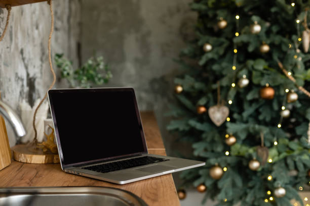 istock Laptop. Christmas tree and gifts on background 1356991929