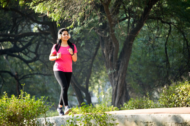 istock Woman listening music while jogging at park 1356994323