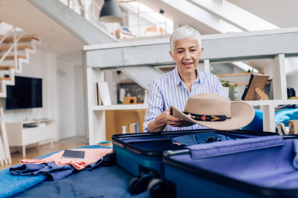 istock Senior woman packing for a travel 1356994509