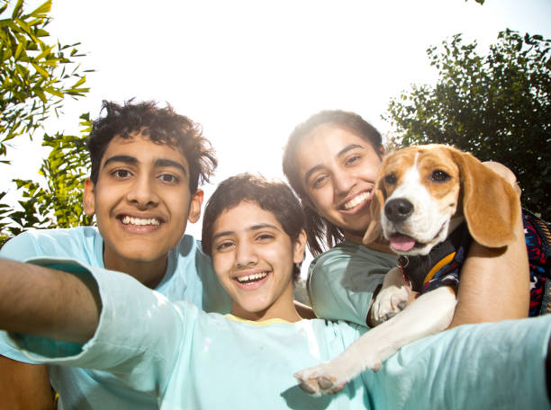 istock Teenagers with pet dog talking selfie 1356997786