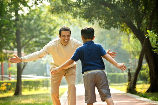 Cheerful father embracing his son at park