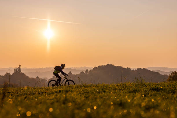 istock Man riding a bicycle on hills at sunset 1356999026