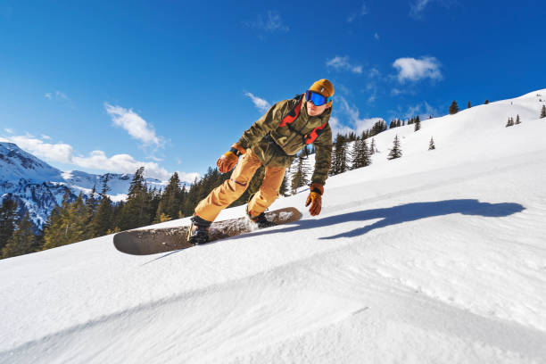 istock Snowboarders riding fast in mountains 1356999083