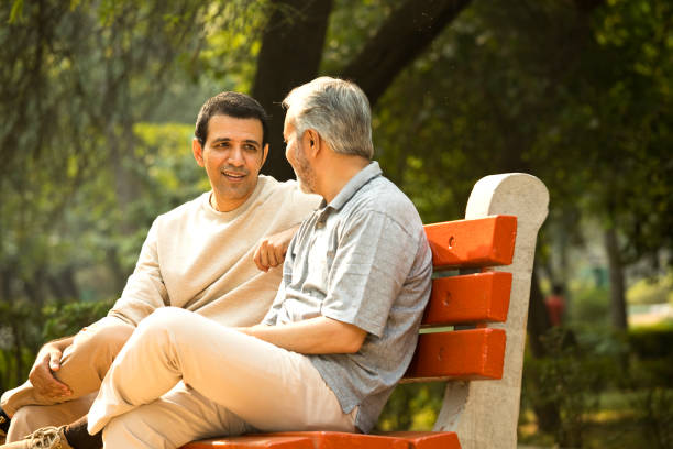Old man spending leisure time with son at park stock photo