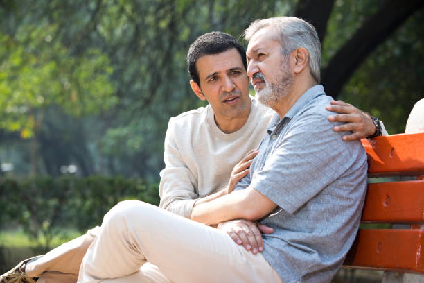 istock Son comforting thoughtful old father at park 1357000360