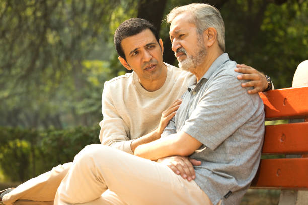 istock Son comforting thoughtful old father at park 1357000370