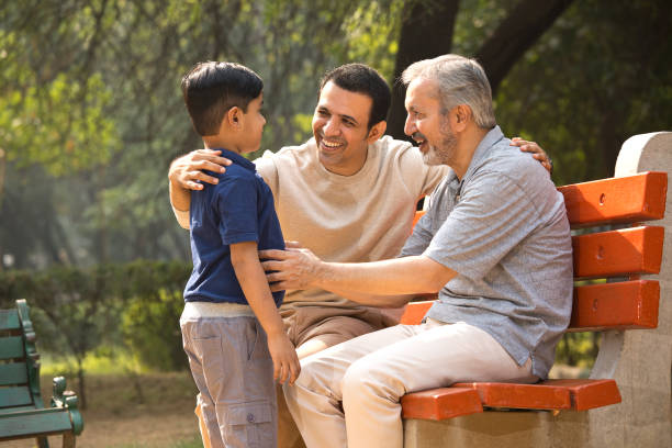 tres generaciones que pasan tiempo libre en el parque - banco asiento fotografías e imágenes de stock