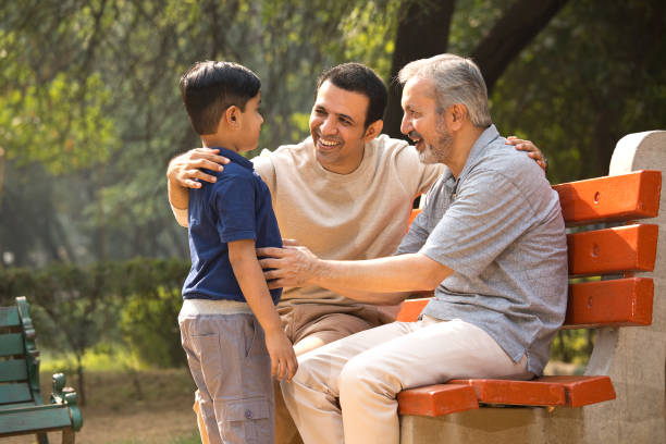 Three generation spending leisure time at park stock photo