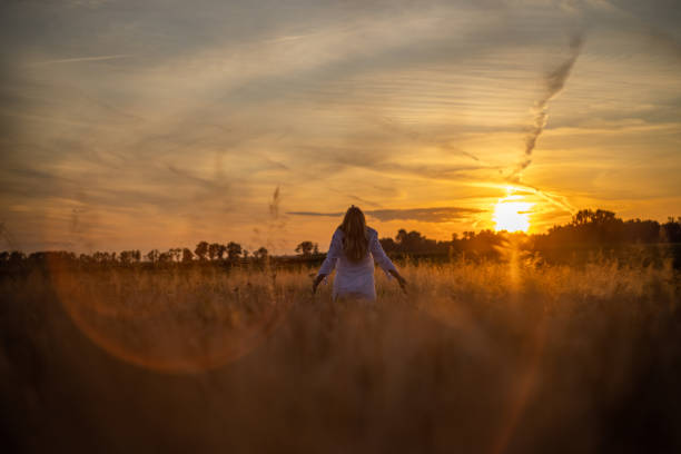 istock Woman in nature looking at sunset 1357000667